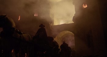 Movie still from “Time Bandits” (1981), directed by Terry Gilliam – A group of people standing next to each other in front of a building; Wide shot, Low angle