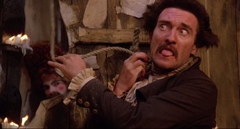 Movie still from “Time Bandits” (1981), directed by Terry Gilliam – A man holding a rope in a room with walls; Close Up shot, Overhead angle