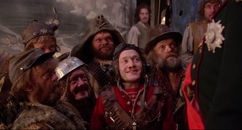 Movie still from “Time Bandits” (1981), directed by Terry Gilliam – A group of people in costumes posing for a picture; Medium shot, Low angle