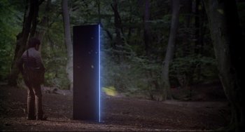 Movie still from “Time Bandits” (1981), directed by Terry Gilliam – A tall black object in the middle of a forest; Extreme Wide shot, Low angle