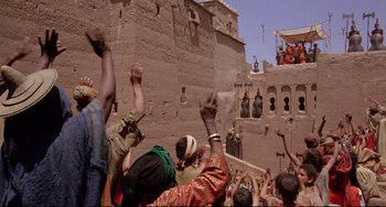 Movie still from “Time Bandits” (1981), directed by Terry Gilliam – A group of people standing next to each other on a street; Extreme Wide shot, Low angle