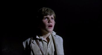 Movie still from “Time Bandits” (1981), directed by Terry Gilliam – A young boy is looking up in the dark; Close Up shot, Low angle