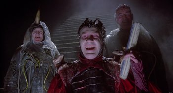 Movie still from “Time Bandits” (1981), directed by Terry Gilliam – A group of people standing next to each other on some steps; Medium shot, Low angle