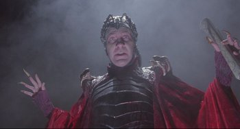 Movie still from “Time Bandits” (1981), directed by Terry Gilliam – A man wearing a red and black outfit and a crown; Medium shot, Low angle