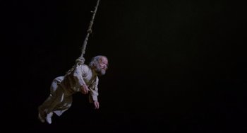 Movie still from “Time Bandits” (1981), directed by Terry Gilliam – An old man hanging from a rope in the dark; Wide shot, Low angle