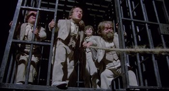 Movie still from “Time Bandits” (1981), directed by Terry Gilliam – A group of people in a cage with ropes; Wide shot, Low angle