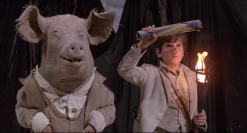 Movie still from “Time Bandits” (1981), directed by Terry Gilliam – A young boy holding a baseball bat next to an animal; Medium shot, Low angle