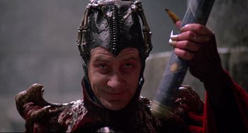 Movie still from “Time Bandits” (1981), directed by Terry Gilliam – A man in a costume holding a knife; Close Up shot, Low angle