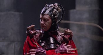 Movie still from “Time Bandits” (1981), directed by Terry Gilliam – A man in a red outfit and a metal helmet; Close Up shot, Low angle