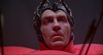 Movie still from “Time Bandits” (1981), directed by Terry Gilliam – A person wearing a red costume; Close Up shot, Low angle