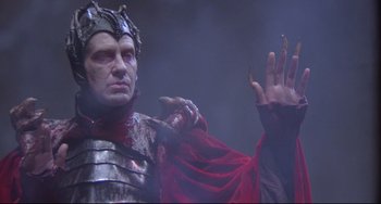 Movie still from “Time Bandits” (1981), directed by Terry Gilliam – A man dressed as a medieval knight in a red cape; Medium shot, Low angle