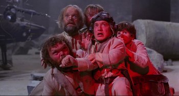 Movie still from “Time Bandits” (1981), directed by Terry Gilliam – A group of people standing next to each other in a room; Medium shot, Low angle