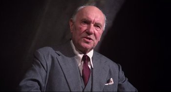 Movie still from “Time Bandits” (1981), directed by Terry Gilliam – An older man wearing a suit and tie; Close Up shot, Low angle