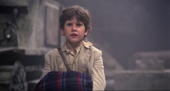 Movie still from “Time Bandits” (1981), directed by Terry Gilliam – A young boy with a bag in his hands; Close Up shot, Over the shoulder angle