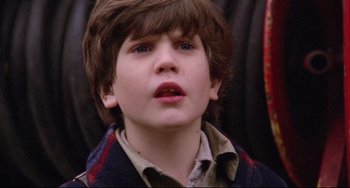 Movie still from “Time Bandits” (1981), directed by Terry Gilliam – A young boy is looking at the camera; Close Up shot, Over the shoulder angle