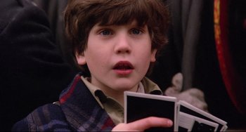 Movie still from “Time Bandits” (1981), directed by Terry Gilliam – A young boy is holding a book in his hands; Close Up shot, High angle