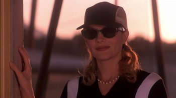 Movie still from “Tin Cup” (1996), directed by Ron Shelton – A person wearing sunglasses and a hat; Close Up shot, Low angle