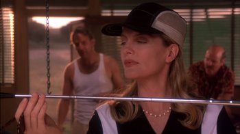 Movie still from “Tin Cup” (1996), directed by Ron Shelton – A man and a woman in a baseball cap and tank top; Close Up shot, Low angle