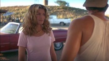 Movie still from “Tin Cup” (1996), directed by Ron Shelton – A woman standing next to another woman in a parking lot; Medium shot, Over the shoulder angle