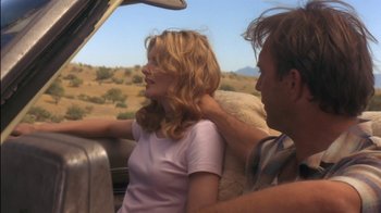 Movie still from “Tin Cup” (1996), directed by Ron Shelton – A man and a woman sitting in the back of a car; Medium shot, Low angle