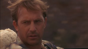 Movie still from “Tin Cup” (1996), directed by Ron Shelton – A person wearing a plaid shirt; Close Up shot, Over the shoulder angle