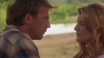 Movie still from “Tin Cup” (1996), directed by Ron Shelton – A man and a woman face to face in a field; Close Up shot, Over the shoulder angle