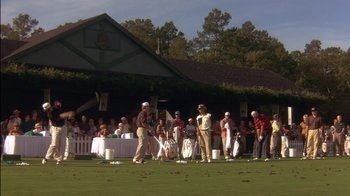 Movie still from “Tin Cup” (1996), directed by Ron Shelton – A group of people standing on top of a golf course; Extreme Wide shot, High angle