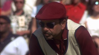 Movie still from “Tin Cup” (1996), directed by Ron Shelton – A person wearing sunglasses and a hat; Close Up shot, Low angle