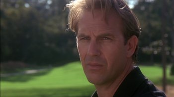 Movie still from “Tin Cup” (1996), directed by Ron Shelton – A man's face in front of a green field; Close Up shot, Low angle