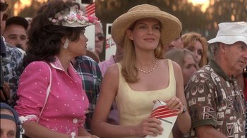 Movie still from “Tin Cup” (1996), directed by Ron Shelton – A woman in a straw hat holding a purse; Medium shot, Low angle