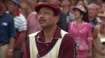 Movie still from “Tin Cup” (1996), directed by Ron Shelton – A man wearing a maroon hat and a maroon vest; Close Up shot, Low angle