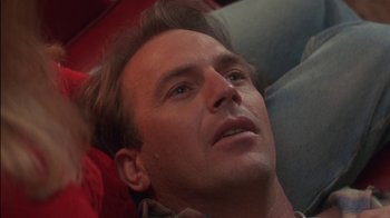 Movie still from “Tin Cup” (1996), directed by Ron Shelton – A person laying on a couch; Close Up shot, Over the shoulder angle