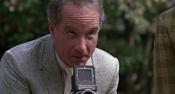 Movie still from “Tin Men” (1987), directed by Barry Levinson – A person holding a camera; Close Up shot, Low angle