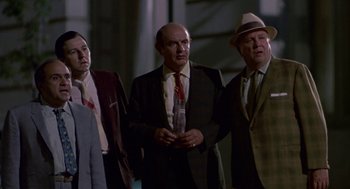 Movie still from “Tin Men” (1987), directed by Barry Levinson – A group of men standing next to each other wearing suits; Medium shot, Low angle