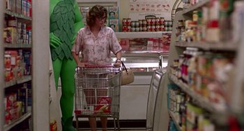 Movie still from “Tin Men” (1987), directed by Barry Levinson – A woman pushing a shopping cart in a grocery store; Wide shot, Low angle