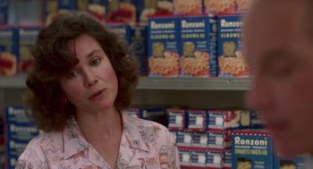 Movie still from “Tin Men” (1987), directed by Barry Levinson – A woman standing in front of a wall of cereal boxes; Close Up shot, Over the shoulder angle