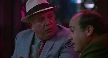 Movie still from “Tin Men” (1987), directed by Barry Levinson – A man wearing a suit and a hat talking to another man; Close Up shot, Over the shoulder angle