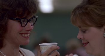 Movie still from “Tin Men” (1987), directed by Barry Levinson – Two women are holding cups of coffee and smiling; Close Up shot, Over the shoulder angle