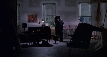 Movie still from “Tin Men” (1987), directed by Barry Levinson – A man and a woman kissing in a living room; Wide shot, Low angle