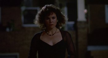 Movie still from “Tin Men” (1987), directed by Barry Levinson – A woman wearing a black dress and a necklace; Close Up shot, Low angle