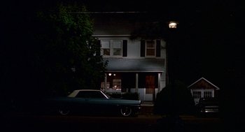 Movie still from “Tin Men” (1987), directed by Barry Levinson – A car parked in front of a house at night; Extreme Wide shot, Low angle