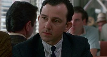 Movie still from “Tin Men” (1987), directed by Barry Levinson – A person wearing a suit and tie; Close Up shot, Over the shoulder angle