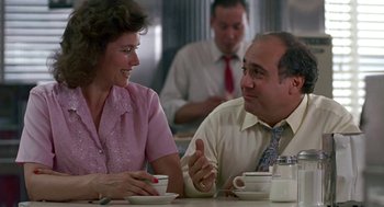 Movie still from “Tin Men” (1987), directed by Barry Levinson – A man and a woman sitting at a table talking to each other; Medium shot, Over the shoulder angle