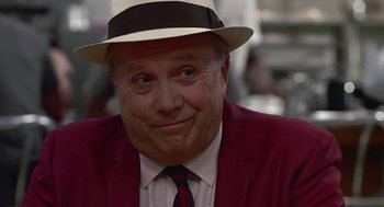 Movie still from “Tin Men” (1987), directed by Barry Levinson – A person wearing a suit and hat; Close Up shot, Over the shoulder angle