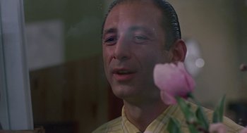 Movie still from “Tin Men” (1987), directed by Barry Levinson – A person holding a pink flower; Close Up shot, Low angle