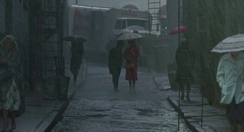 Movie still from “Tin Men” (1987), directed by Barry Levinson – Two people walking down a street with an umbrella; Extreme Wide shot, High angle