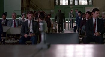 Movie still from “Tin Men” (1987), directed by Barry Levinson – A group of people in suits and ties sitting in a room; Wide shot, High angle