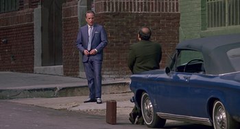 Movie still from “Tin Men” (1987), directed by Barry Levinson – A man in a suit and tie standing next to a man in a suit; Wide shot, Over the shoulder angle