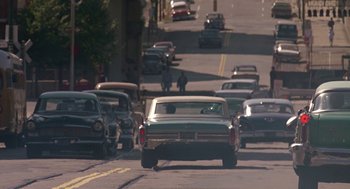 Movie still from “Tin Men” (1987), directed by Barry Levinson – A group of cars driving down a street; Extreme Wide shot, High angle
