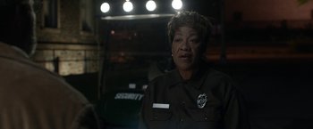 A woman in a police uniform standing in front of lights